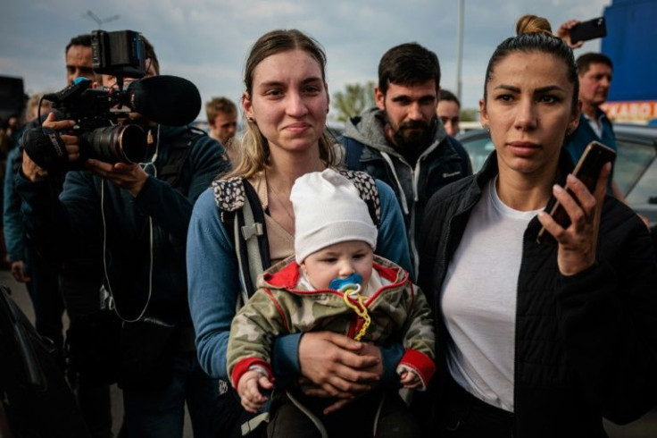 Evacuee Anna Zaitseva (C), holding her six-month-old son, described being knocked to the ground by an explosion