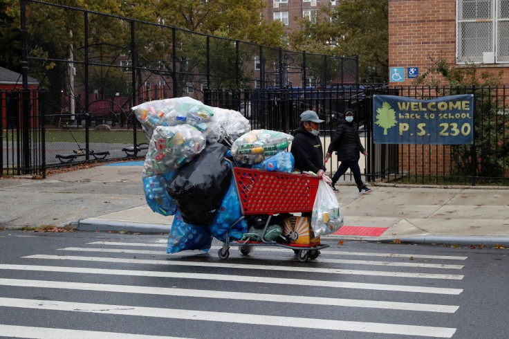A man with a protective face mask walks with recyclables in a shopping cart as the spread of coronavirus disease (COVID-19) continues in the borough of Brooklyn in New York, U.S., October 13, 2020.