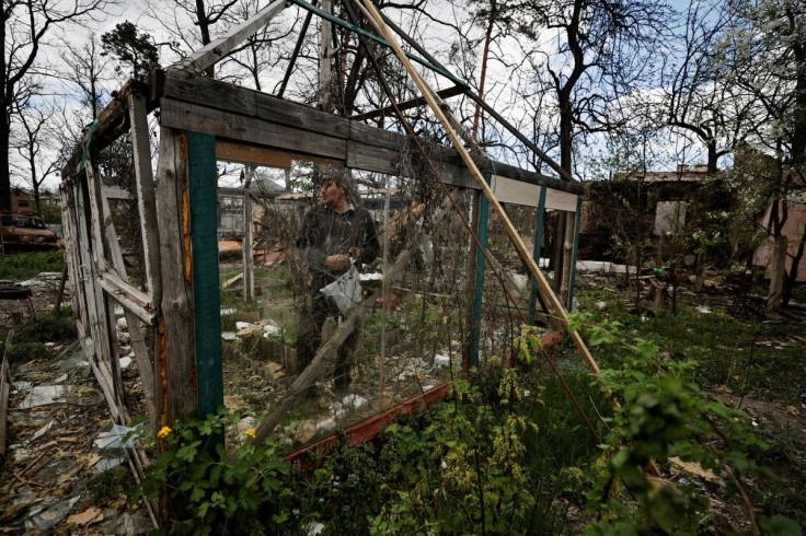 Oleksiy Sokolyuk, 50, reacts while he picks common morning glory flower seeds at the garden of his house, that according to him was destroyed by shelling, the first on March 5, and the second on March 17, amid Russian invasion of Ukraine, in Irpin, outsid