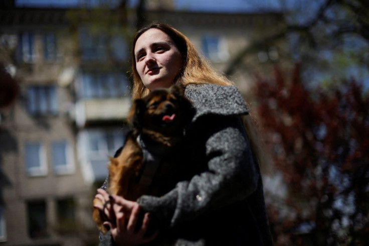 Tetyana Trotsak, a Ukrainian woman evacuee from Mariupol, walks with her dog in front a hotel used as temporary shelter, amid Russia's invasion of Ukraine, in Zaporizhzhia, Ukraine May 4, 2022. 