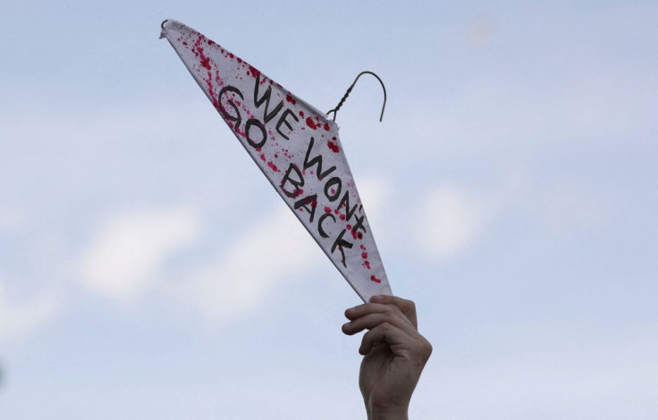 A protester holds a wire hanger while participating in a pro-abortion rights march and rally held in reaction to the leak of a draft U.S. Supreme Court majority opinion written by Justice Samuel Alito preparing for a majority of the court to overturn the 