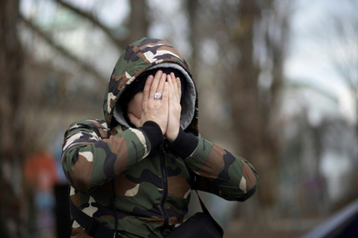 Living in fear: A young exile in Vienna wearing a Chechen ring covers his face