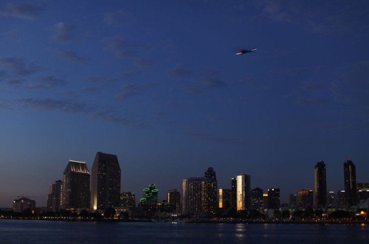 A military helicopter flies past the  skyline of San Diego, California October 7, 2014.  
