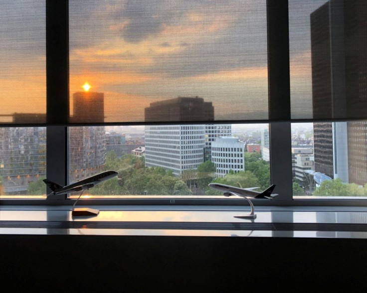 The sun sets behind an office window with models of Lufthansa and Qatar Airways planes, in Frankfurt, Germany, May 4, 2022.