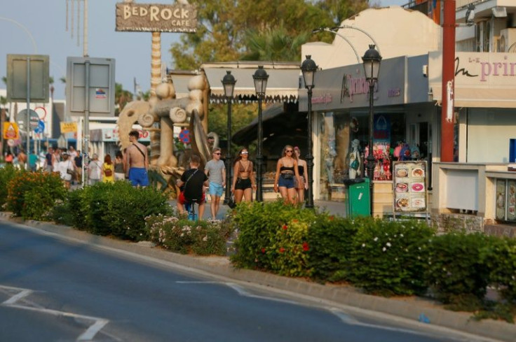 Tourists walk in the Cypriot resort town of Ayia Napa on July 18, 2019