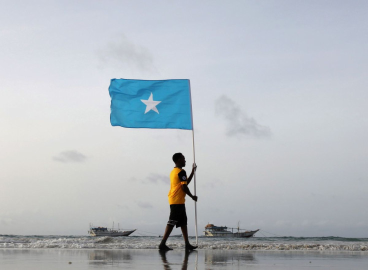 A Somali youth holds the national flag, at Lido beach, Mogadishu's Abdiaziz District, Somalia June 18, 2021.
