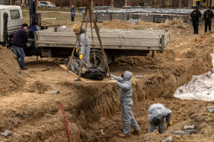 Workers exhume bodies at a site in Bucha, Ukraine where civilians killed during Russian occupation were buried, amid allegations of many war crimes by Russian fighters in the Kyiv suburb.