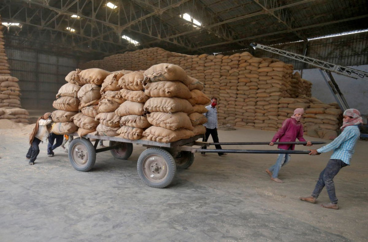 Labourers move a cart loaded with rice bags inside a food processing unit, which was reopened after weeks-long shutdown to slow the spread of coronavirus disease (COVID-19), on the outskirts of Ahmedabad, India, April 20, 2020. 