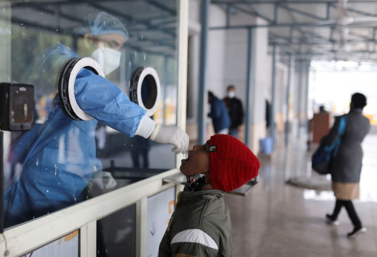 A healthcare worker collects a swab sample from a child amid the spread of the coronavirus disease (COVID-19), at a testing center inside a hospital in New Delhi, India, January 14, 2022. 