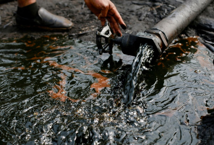A person operates a tap of crude oil during the destruction of Bakana ii illegal camp, in Okrika, Rivers state, Nigeria January 28, 2022.
