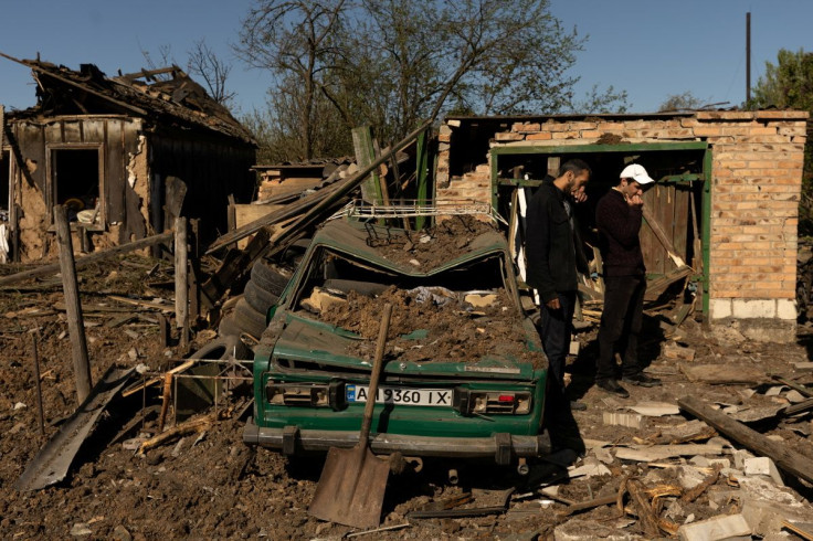 Men react as they stand in front of their house after a missile strike hit a residential area, amid Russia's invasion in Ukraine, in Bakhmut in the Donetsk region, Ukraine, May 7, 2022.