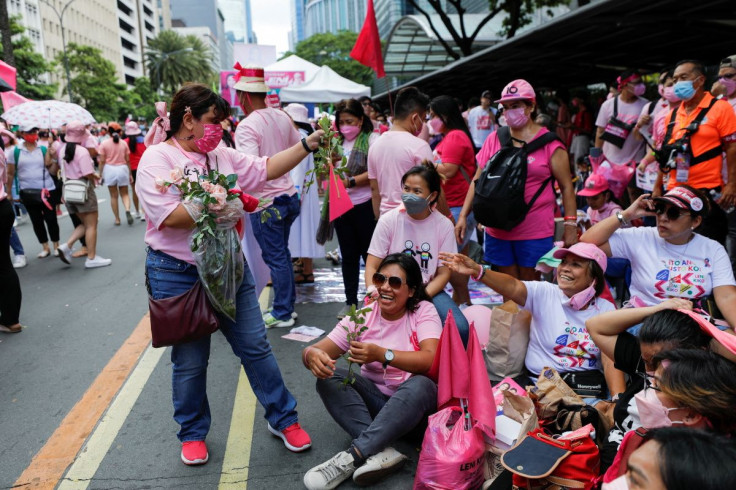 Supporter of Philippine Vice President and presidential candidate Leni Robredo distributes flowers to the women while taking part on a campaign rally ahead of the 2022 national elections in Makati, Metro Manila, Philippines, May 7, 2022.