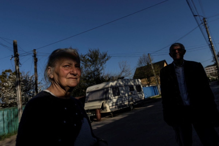 Zinaida Baranchuk, 72, stands by a caravan where she lives with her son and which is parked outside her house which was destroyed after Russian shelling, amid Russia's invasion of Ukraine, in Irpin, Ukraine May 6, 2022. Picture taken May 6, 2022.