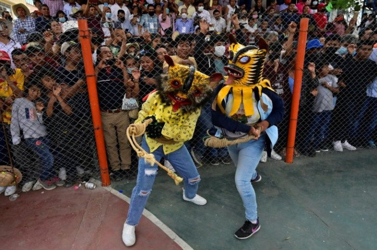 Women in tiger costumes take part in the tiger fight during the rain petition ritual in Zitlala, Guerrero state, Mexico on May 5, 2022