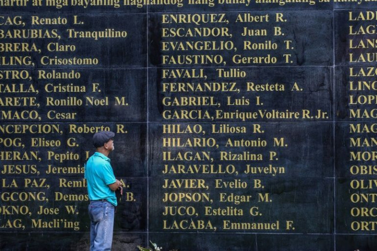 Former political prisoner Bonifacio Ilagan looks at the "Wall of Remembrance" showing names of victims from the martial law era under former dictator Ferdinand Marcos