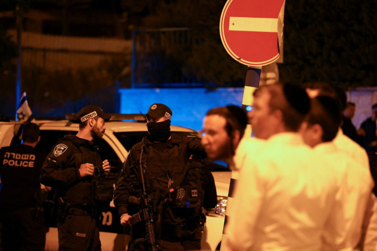 Local residents and Israeli security personnel gather in the area where at least three people were killed in what police suspect was a Palestinian attack, on Israeli Independence Day, in Elad, Israel, May 6, 2022.
