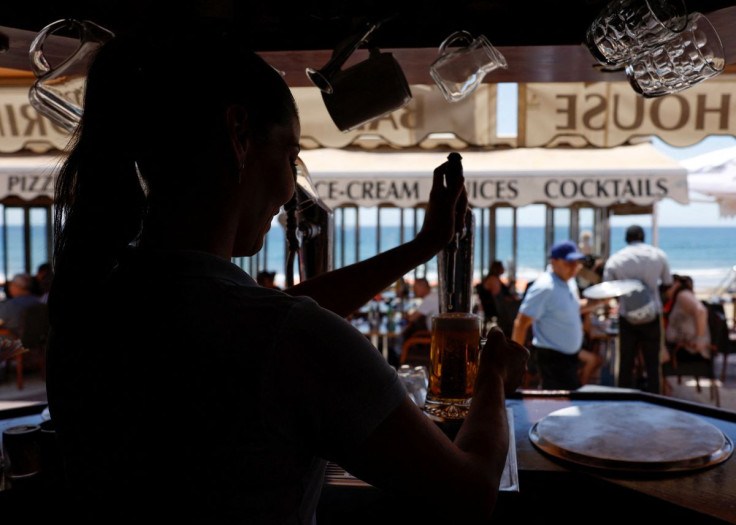 A waitress pours beer in a restaurant in Playa del Ingles, Maspalomas on the island of Gran Canaria, Spain, May 3, 2022.