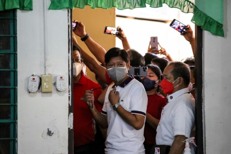 Philippine presidential candidate Ferdinand Marcos Jr (C) cast his vote at Mariano Marcos Memorial Elementary in his family's traditional stronghold of Ilocos Norte on Monday