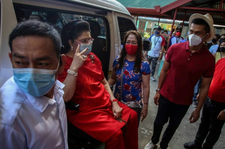 Imelda Marcos (2nd L), mother of Philippine presidential candidate Ferdinand Marcos Jr, arrives at a polling station in Ilocos Norte