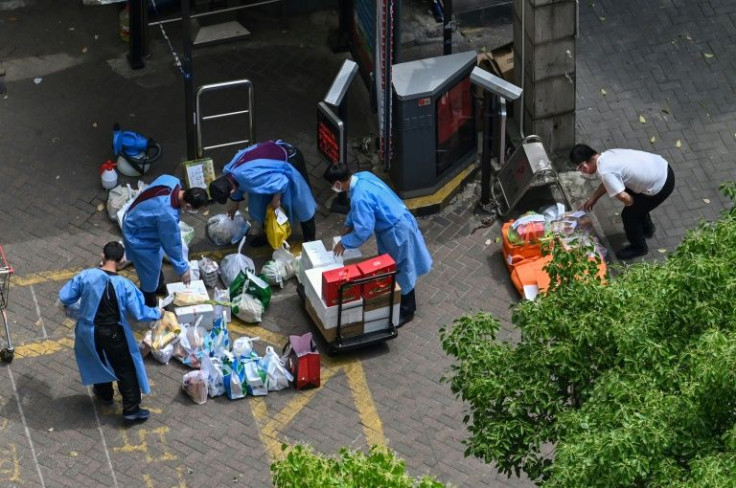 Workers receive deliveries at the entrance of a building during a Covid-19 coronavirus lockdown in Jing'an district, Shanghai