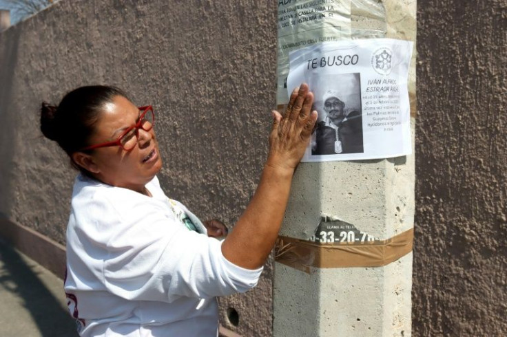Azulema Estrada puts up a poster seeking information about her son Ivan Alfredo, one of more than 95,000 people missing in Mexico