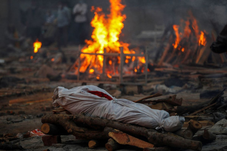 The body of a person, who died from the coronavirus disease, lies on a funeral pyre during a mass cremation at a crematorium in New Delhi, India May 1, 2021. 