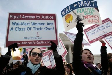 Women protesters hold signs in front of the Supreme Court