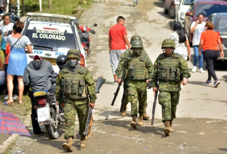 Soldiers walk outside the Bellavista prison after a riot at the facility in Ecuador that left at least 43 inmates dead