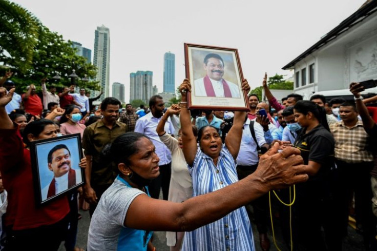Sri Lankan government supporters carried prime minister Mahinda Rajapaksa's portrait while protesting outside the outgoing premier's residence in Colombo on May 9, 2022