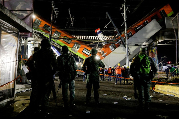 Soldiers stand as rescuers work at a site where an overpass for a metro partially collapsed with train cars on it at Olivos station in Mexico City, Mexico, May 4, 2021.