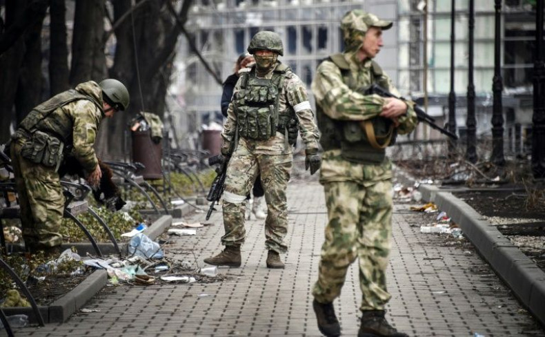 Russian soldiers walks along a street in Mariupol, Ukraine in a campaign to take the strategic port city.