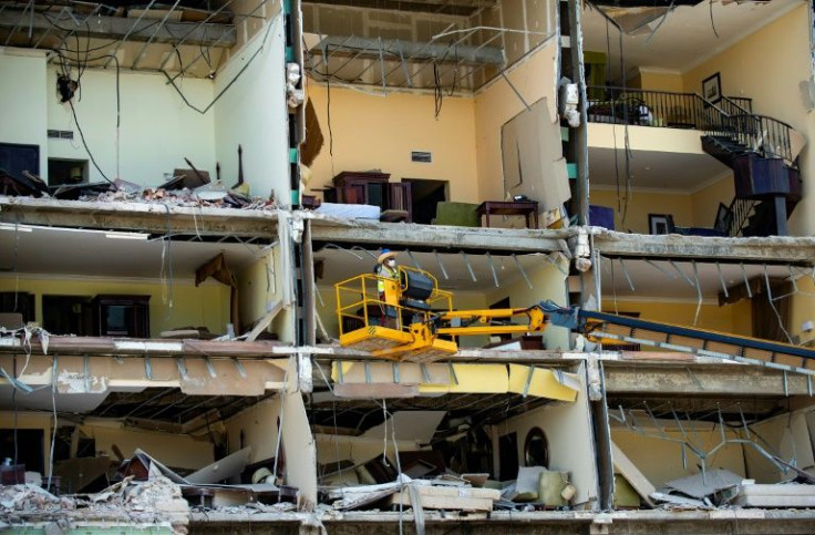 Men work on a crane at the remains of the Saratoga Hotel in Havana, on May 10, 2022, days after an explosion destroyed it and killed at least 42 people