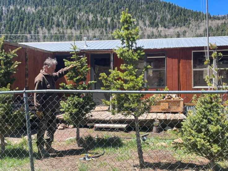 A rancher wets down his home as he prepares to evacuate from the Hermits Peak Calf Canyon Fire, in Angostura, New Mexico, U.S., May 9, 2022. Picture taken May 9, 2022.
