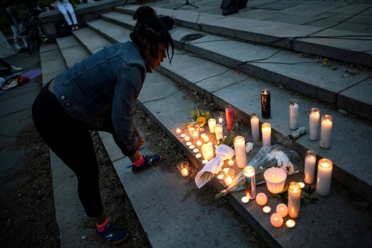 A woman lights candles as people participate in a "Black Lives Lost to Gun Violence" vigil in Brooklyn, New York, U.S., April 28, 2021.