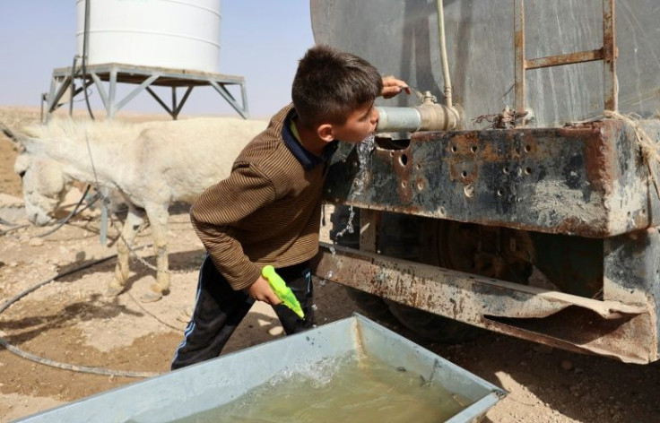 A boy drinks water in the Palestinian village of Jinba, part of the Masafer Yatta area in the Israeli-occupied West Bank