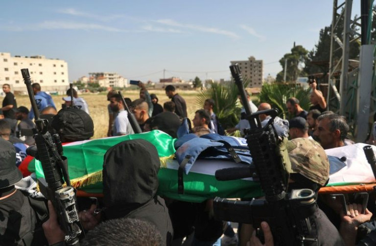 Masked Palestinian gunmen carry the body of veteran Al Jazeera journalist Shireen Abu Aqleh though the streets of Jenin before it is transferred to Jerusalem for the funeral