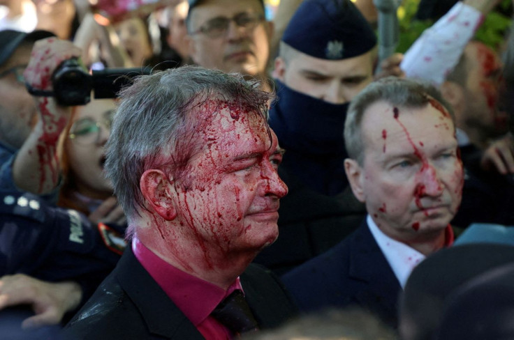 Russia's ambassador to Poland Sergey Andreev is covered in red substance thrown by protesters as he came to celebrate Victory day at the Soviet Military Cemetery to mark the 77th anniversary of the victory over Nazi Germany, in Warsaw, Poland May 9, 2022.