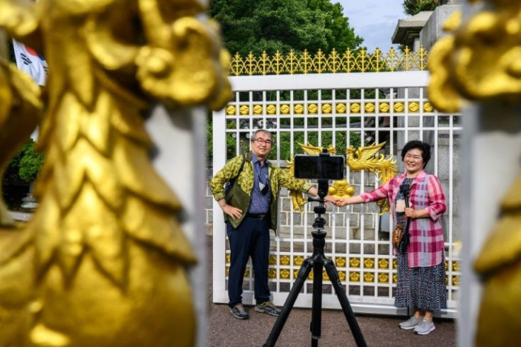 Visitors took selfies in front of the gates in the Blue House compound