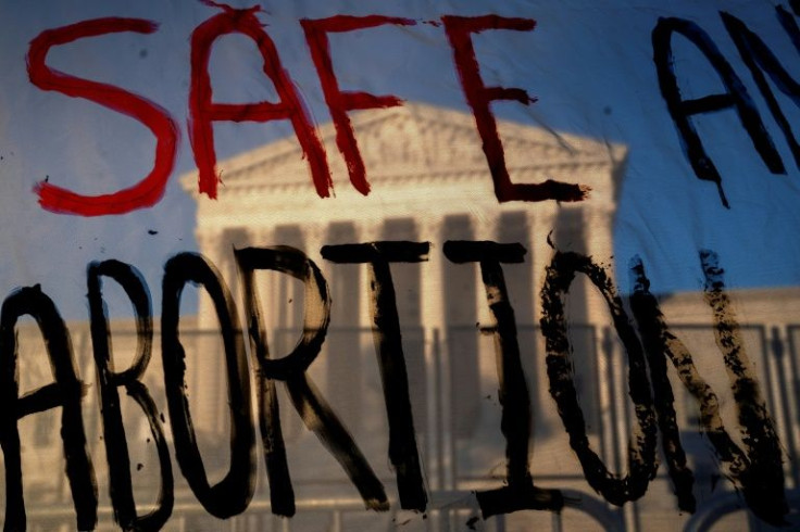 The US Supreme Court is seen through a banner reading 'Safe Abortion' in Washington on May 10, 2022