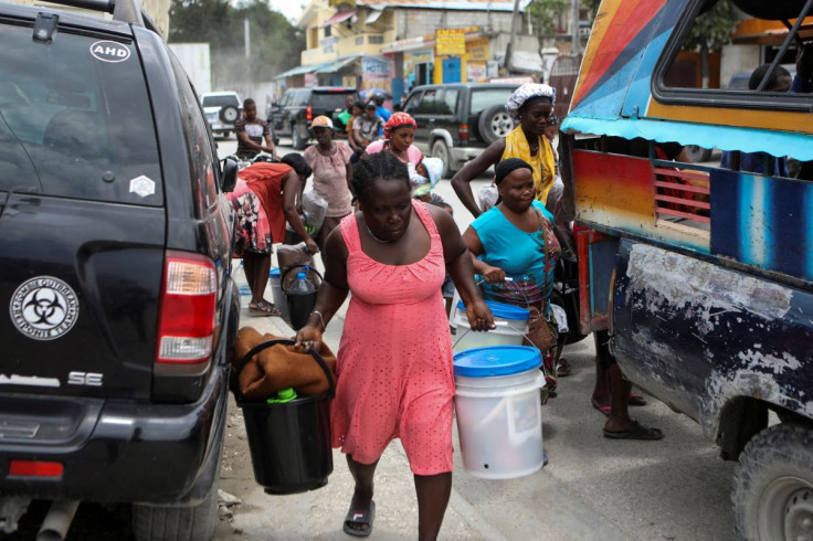 People carry belongings as they flee their homes due to ongoing gun battles between rival gangs, in Port-Au-Prince, Haiti April 28, 2022. 