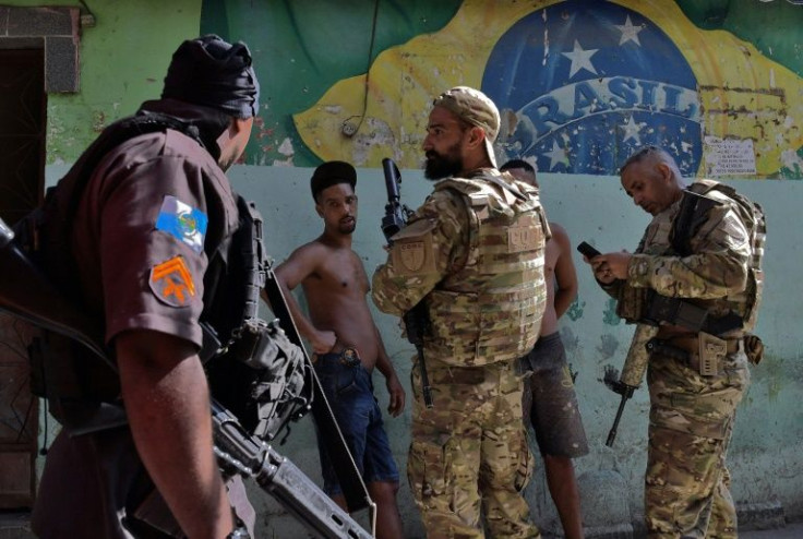 Rio de Janeiro state police special forces, pictured on January 19, 2022, check two men's IDs in the Jacarezinho favela, under a plan aimed at wresting back control of the neighborhood from drug traffickers