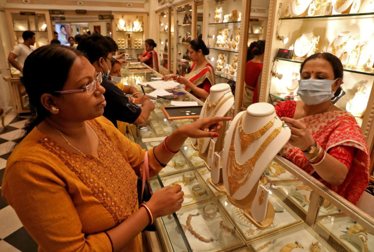 A customer checks a gold necklace before buying it at a jewellery showroom on the occasion of Akshaya Tritiya, a major gold buying festival, in Kolkata, India, May 3, 2022. 