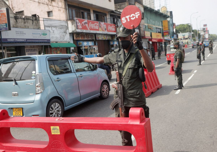 An army member stops vehicles at a check point on a the main road after the curfew was extended for another extra day following a clash between Anti-government demonstrators and Sri Lanka's ruling party supporters, amid the country's economic crisis, in C