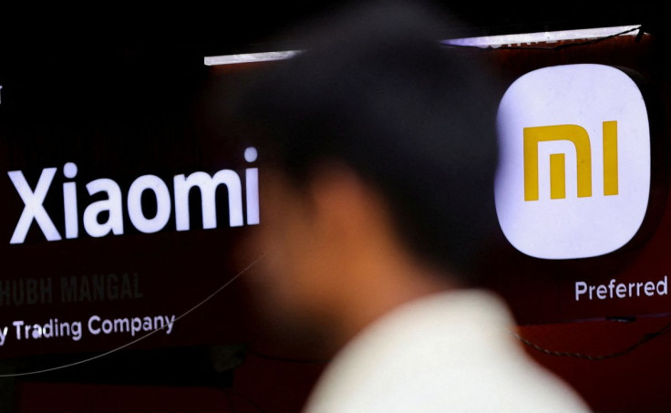 A man walks past a logo of Xiaomi, a Chinese manufacturer of consumer electronics, outside a shop in Mumbai, India, May 11, 2022.