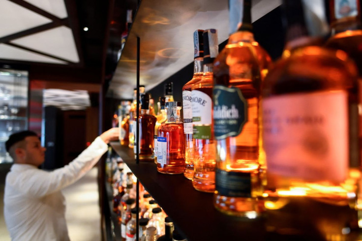 A barman is seen near bottles of spirits at the Camparino bar in Milan, Italy July 12, 2021. Picture taken July 12, 2021.
