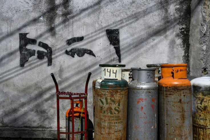 Gas canisters stand next to a mural depicting the eyes of Venezuela's late President Hugo Chavez at a gas distribution point in the neighbourhood of San Bernardino in Caracas, Venezuela May 2, 2022.