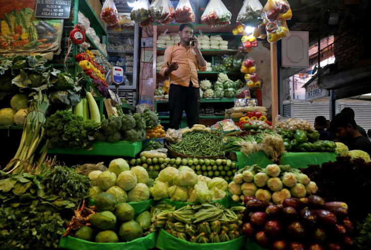 Debashis Dhara, a vegetable vendor, speaks on his mobile phone at a retail market area in Kolkata, India, March 22, 2022.