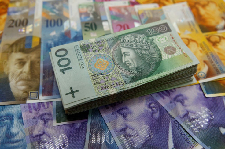 A stack of 100 Polish Zloty banknotes lays on top of various Swiss Franc notes in this picture illustration taken at a bank in Warsaw, July 18, 2011.