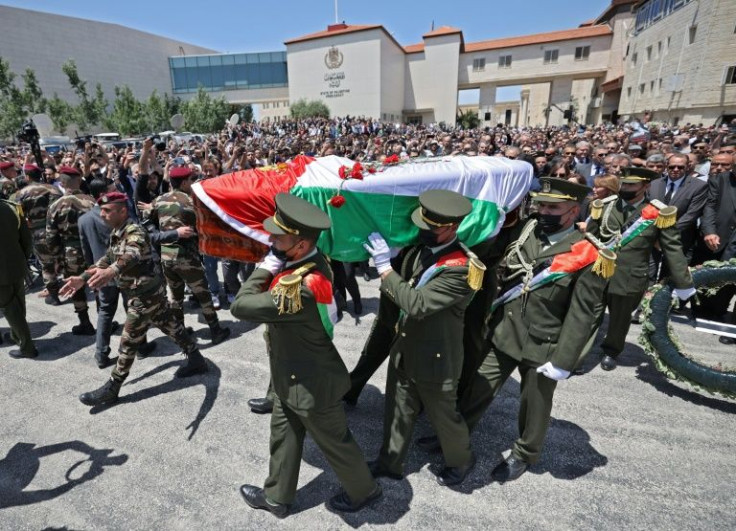 Palestinian honour guards carry the coffin of veteran Al Jazeera journalist Shireen Abu Akleh at the presidential headquarters in the West Bank city of Ramallah