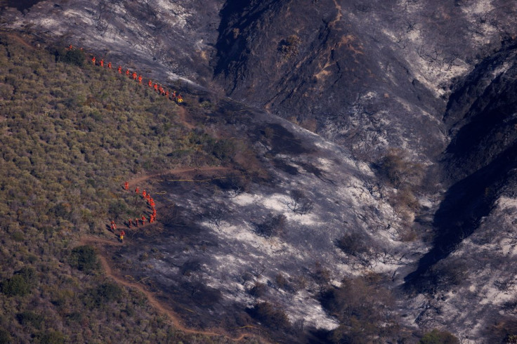 Fire fighting crews make their way along a fire line as progress continues in fighting the Coastal Fire, a wildfire in Laguna Niguel, California, U.S., May 12, 2022.  
